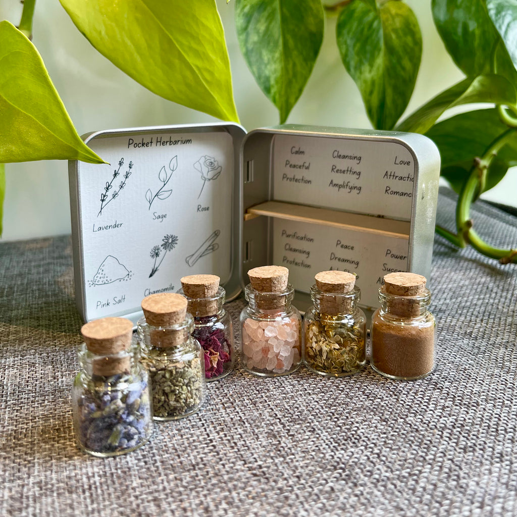 A pocket herbarium. Is is opened like a book. On one side is a list of contents and the other a shelf. 6 bottles are laid out infront. Behind the jars are the properties of the herbs.